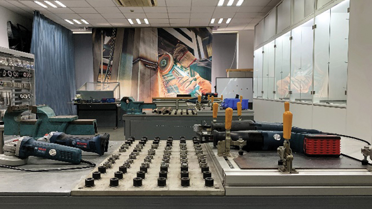 一个博世专业工作区，桌子上摆放着工具，还有一幅大型壁画。