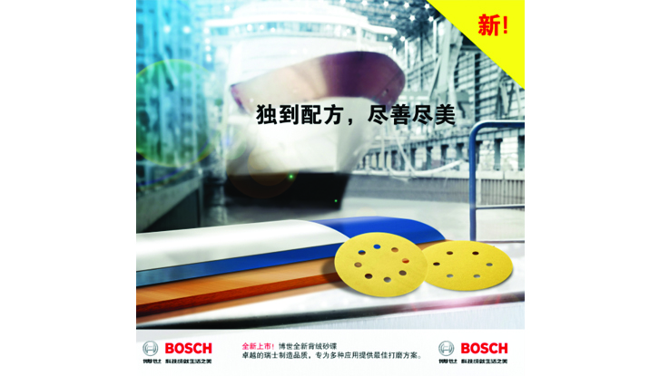 博世砂纸盘，黄色、蓝色和橙色，放置在工作台表面上。