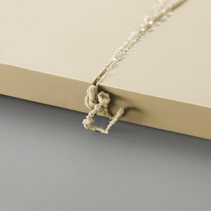 浅色板材钻孔处突出的多余材料残留物。