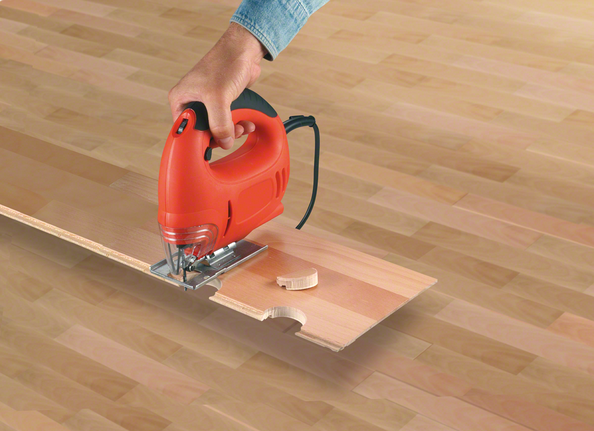 拼图锯在复合地板上切割出弯曲的凹口。.