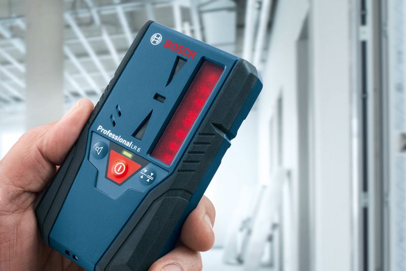 在建建筑物中手持激光接收器的人。.