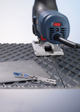 在纹理表面上用曲线锯切割金属板。