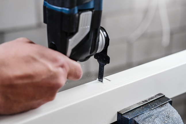 某人使用曲线锯在白板上切割出一个矩形槽。