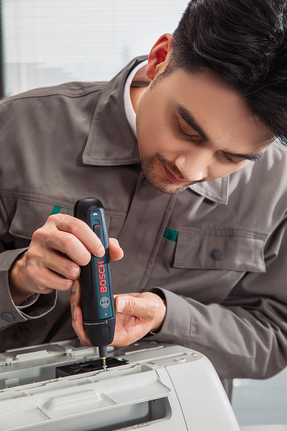 有人正在用无绳螺丝刀组装办公设备。