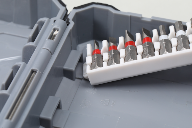 各种螺丝刀头整齐地摆放在灰色工具箱内的塑料支架中。