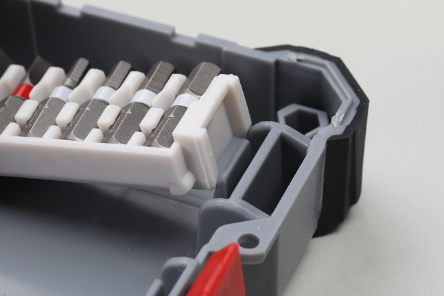 各种螺丝刀头整齐地摆放在一个灰色塑料盒里。