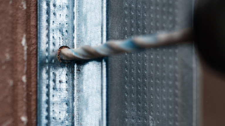 钻头在金属表面钻孔。