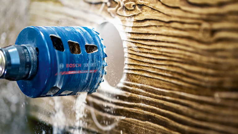 孔锯钻头在木质表面上切割出一个圆孔。