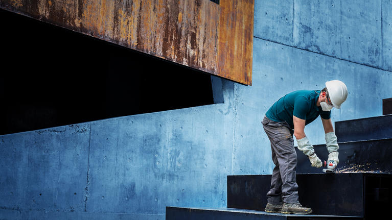 一名佩戴安全设备的人钻进金属楼梯。