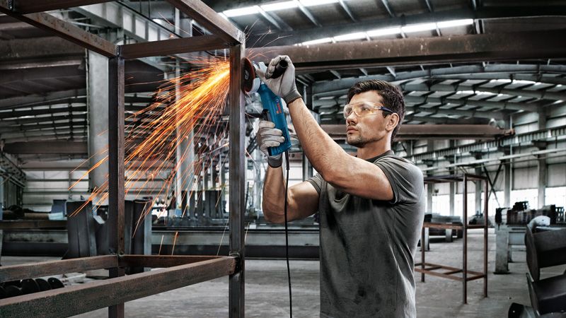 男人磨削金属框架。.