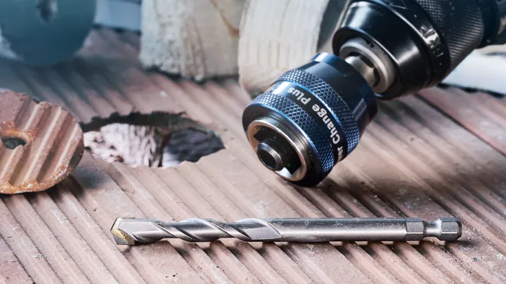 将钻头和钻头放置在新钻孔旁边的凹槽瓷砖表面上。