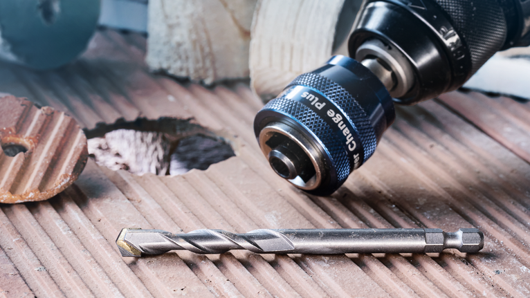 将钻头和钻头放置在新钻孔旁边的凹槽瓷砖表面上。