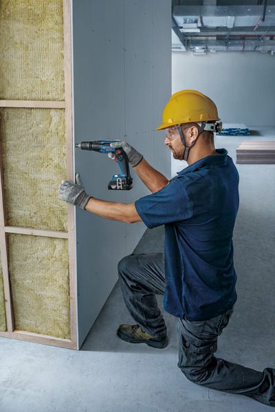 工人正在安装石膏板。.