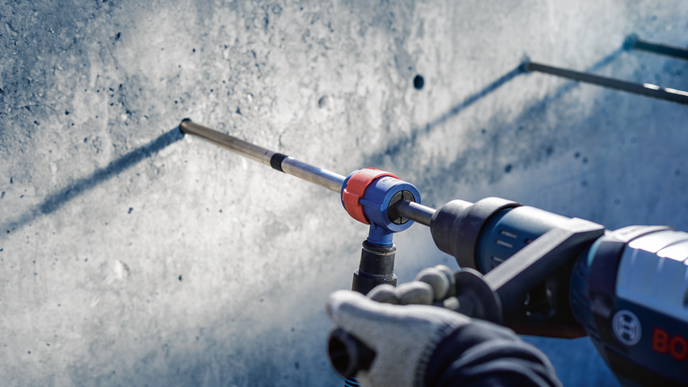 佩戴安全设备的人员正在钻入混凝土墙。