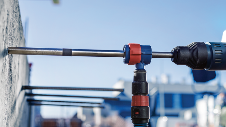 旋转锤在室外的混凝土墙上钻孔。