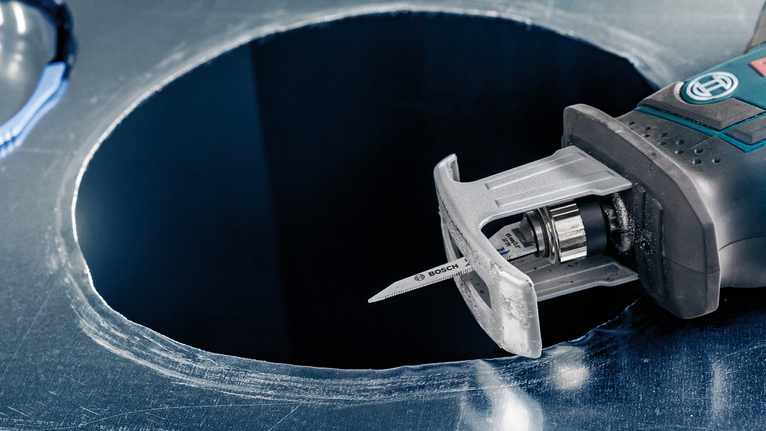 用拼图锯在金属板上切割出一个圆孔。