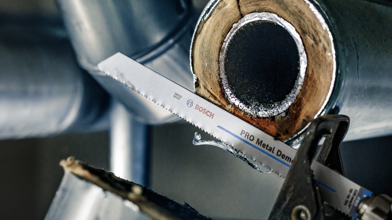 往复锯片在工业环境中切割金属管道。