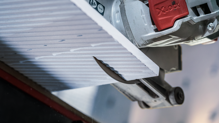 圆锯近距离切割纹理瓷砖面板。