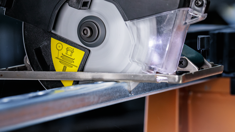 圆锯在车间切割金属梁。