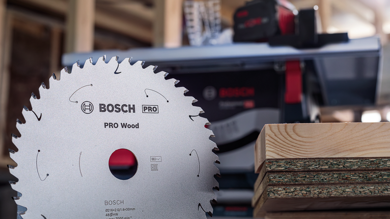 车间内堆放的木板前的圆锯片。