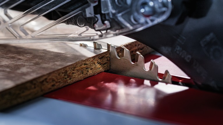 圆锯切割一块刨花板。