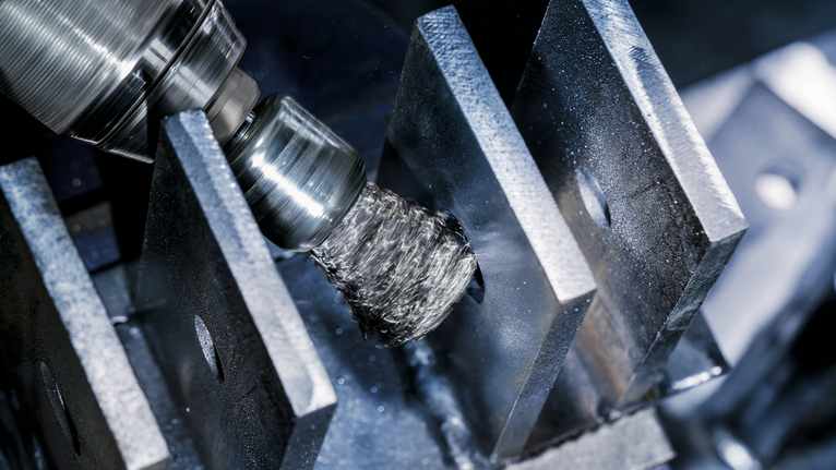 钢丝刷附件在工业环境中抛光金属板。