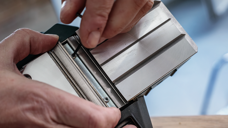 人们使用六角扳手调整金属工具部件。