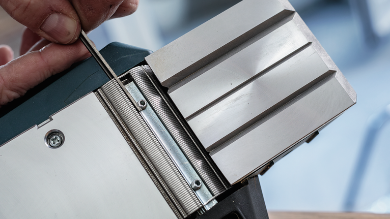 人员使用工具调整金属刨刀。.