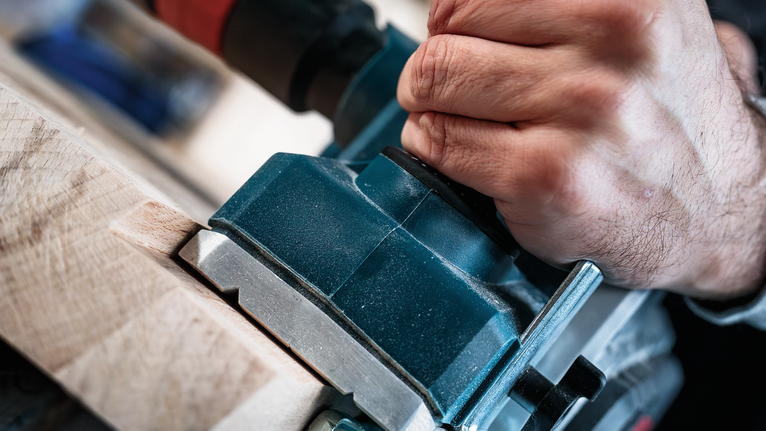 人们使用电动工具来塑造木材。