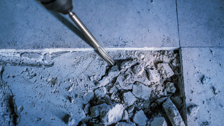 旋转锤凿破碎混凝土地板。