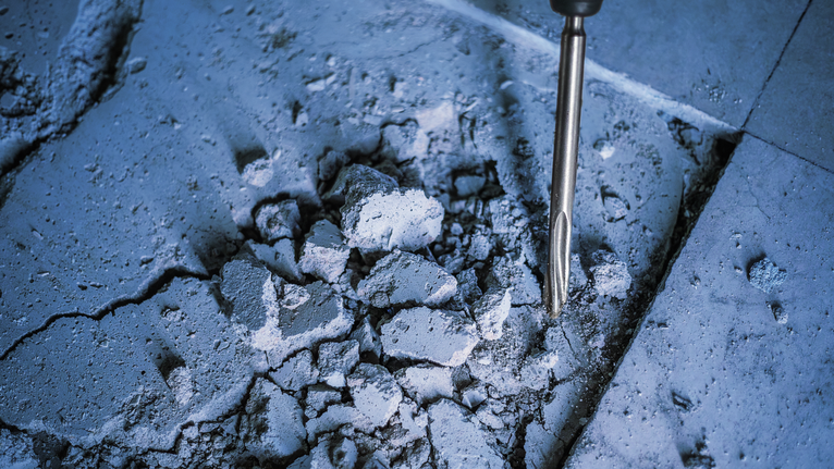 旋转锤砸碎混凝土地板。