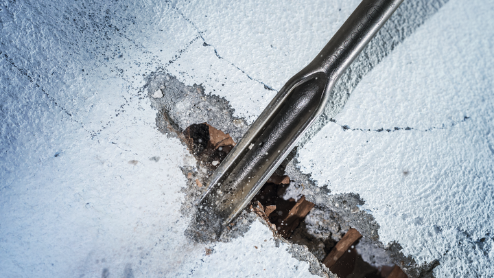 凿子凿穿混凝土以进行拆除工作。