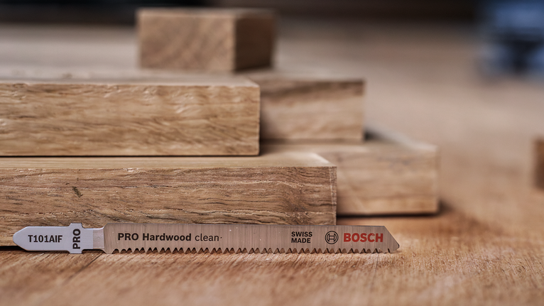 锯片放在堆叠的木板旁边的木质表面上。