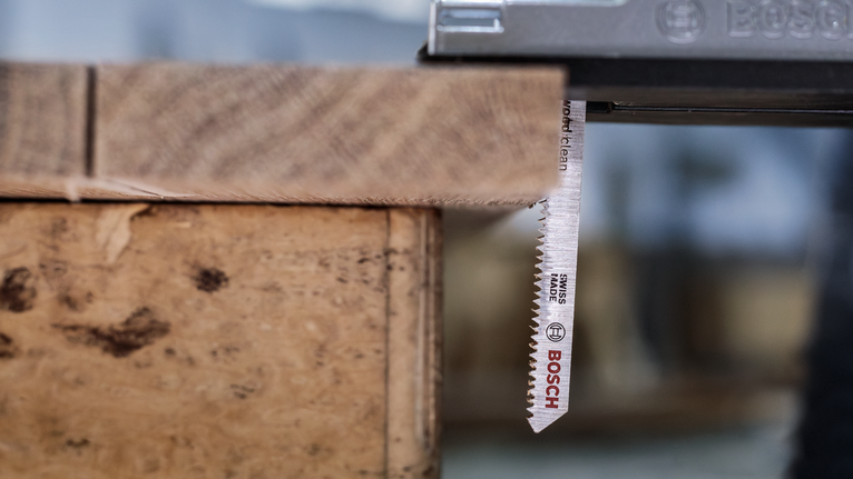 车间里，拼图锯刀片正在切割木板。