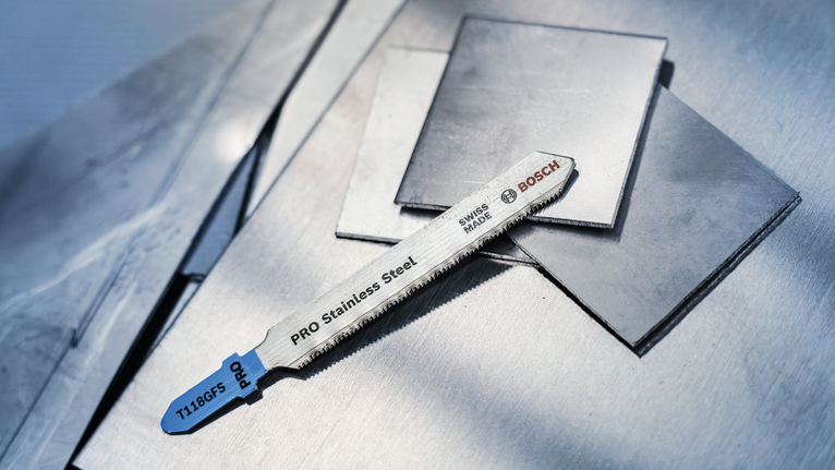 不锈钢拼图锯片放置在平坦的金属板上。