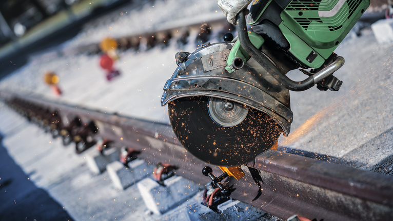 切割锯在户外切割铁轨时产生火花。