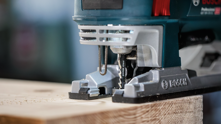 在车间环境中用拼图锯切割木板。