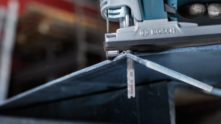 拼图锯沿着标记线切割金属板。