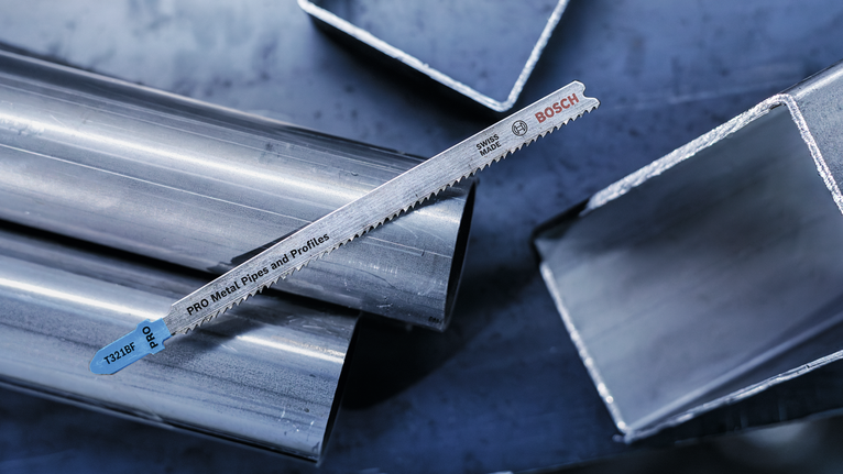 金属锯片放在闪亮的金属管和方管上。