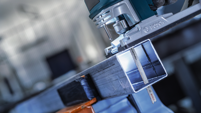 车间里，电动工具正在切割金属梁。