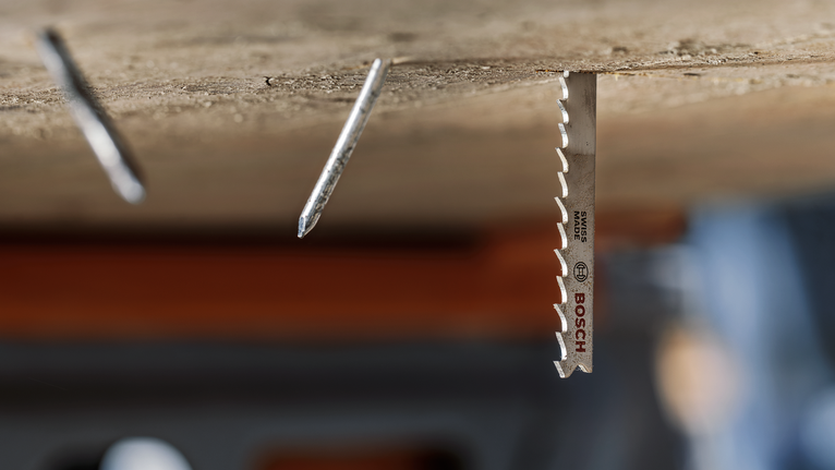 安装在木头上的金属锯片，旁边是两个突出的钉子。