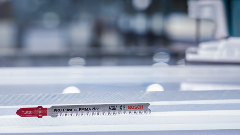 拼图锯刀片放置在车间内的透明塑料板上。