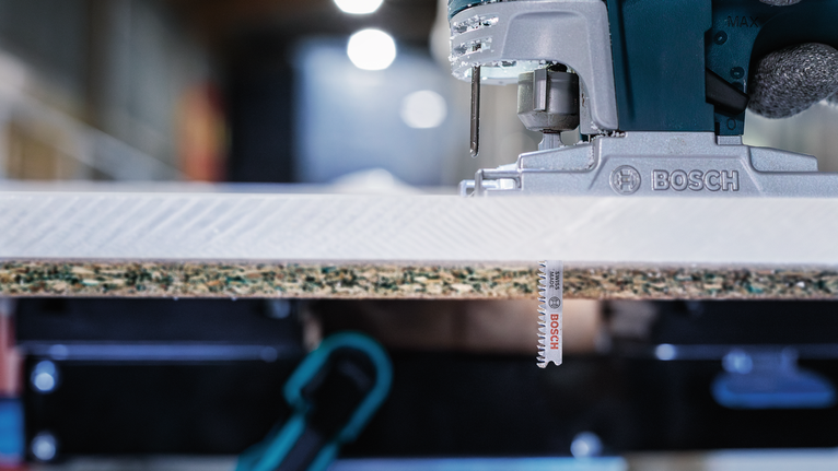 电动曲线锯正在切割一块层压木材。