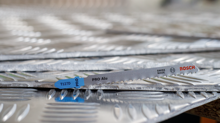 锯片放置在堆叠的纹理金属板上。