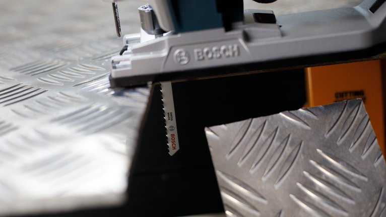 拼图锯切割金属花纹板。