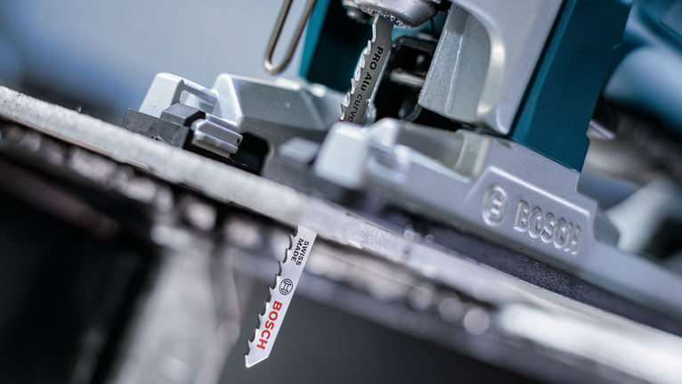 拼图锯刀片切割金属板的特写。