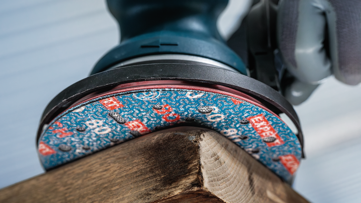 穿着安全设备的人员正在打磨木板的角落。