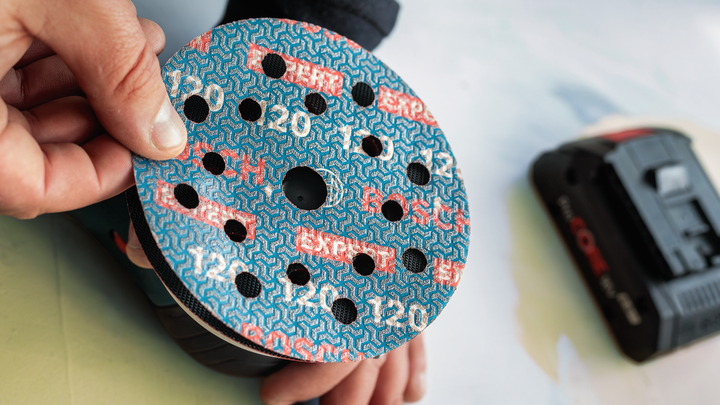 人员将砂磨盘安装到电动砂磨机上。