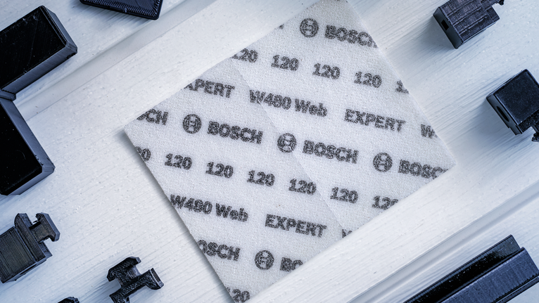 将印有规格的白色磨砂纸放置在浅色木质表面上。