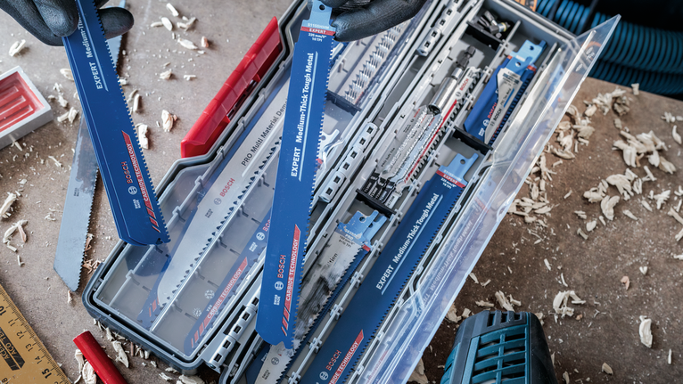 佩戴安全设备的人员从储物箱中选择往复锯片。